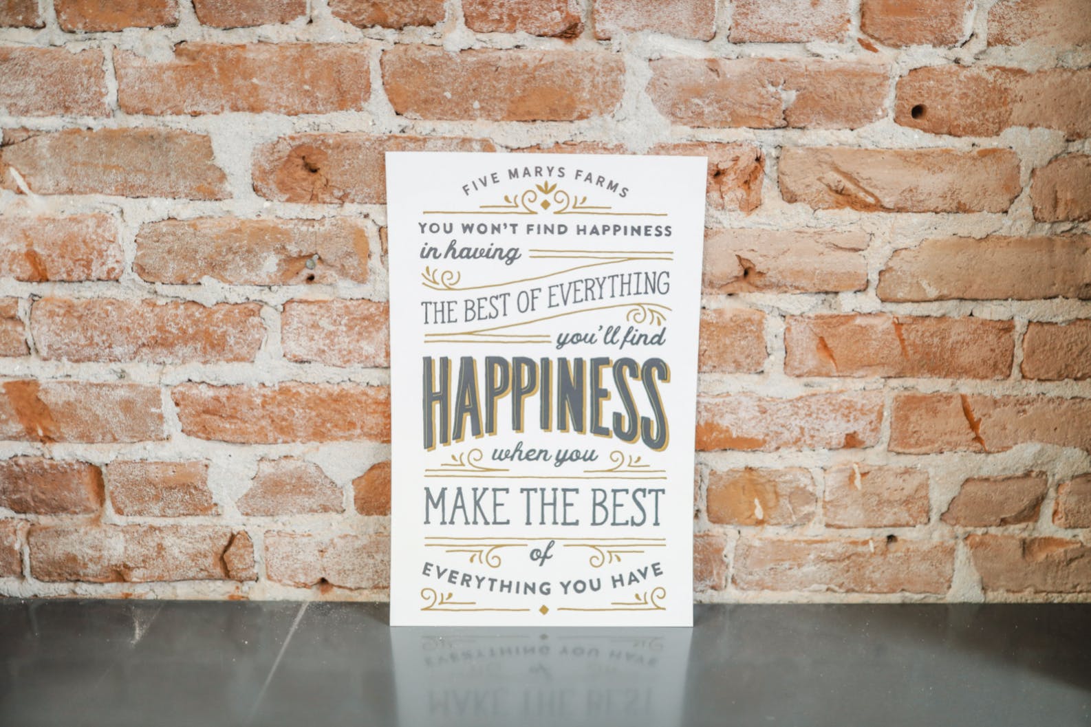 Photo of the M5 Print, "Make the Best" set against a brick wall.